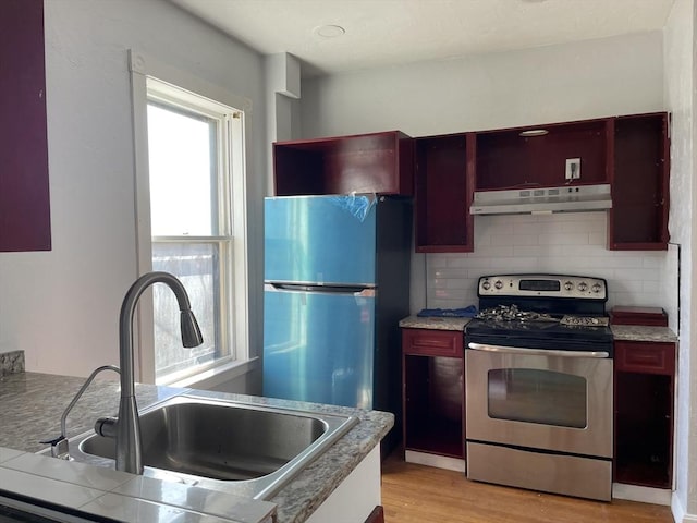 629 Cambridge St, Worcester, MA 01610 - kitchen featuring under cabinet range hood, appliances with stainless steel finishes, a sink, light wood-style flooring, and backsplash