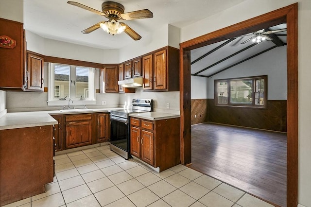 kitchen with sink, light tile patterned floors, ceiling fan, lofted ceiling with beams, and stainless steel range with electric cooktop