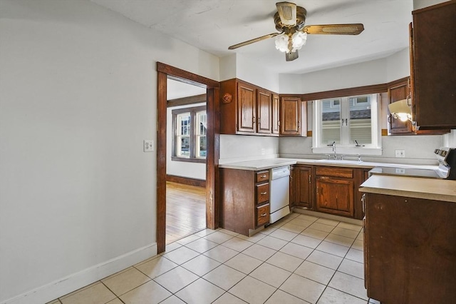 kitchen featuring light tile patterned flooring, dishwasher, sink, range, and ceiling fan