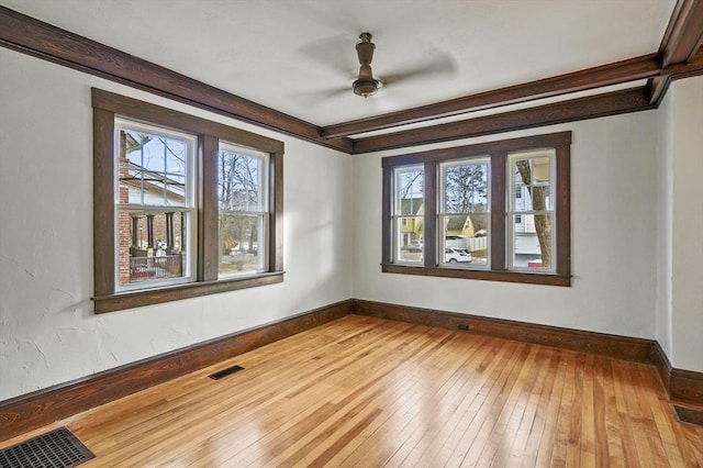 unfurnished room featuring a healthy amount of sunlight, hardwood / wood-style floors, and ceiling fan