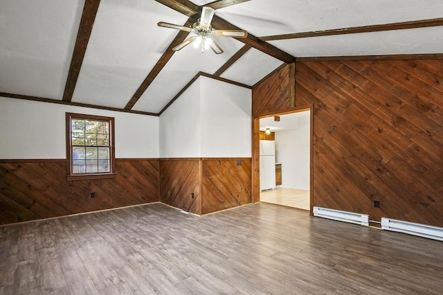 spare room with hardwood / wood-style floors, wooden walls, lofted ceiling with beams, a baseboard radiator, and ceiling fan