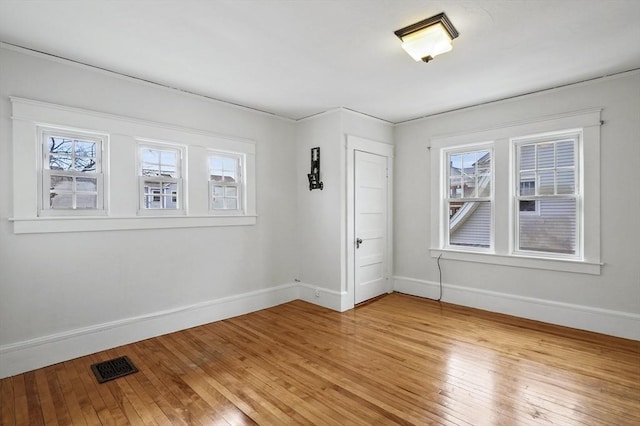 spare room featuring plenty of natural light and light hardwood / wood-style flooring