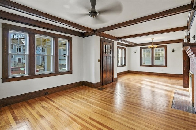 empty room featuring beam ceiling, ceiling fan, and light wood-type flooring