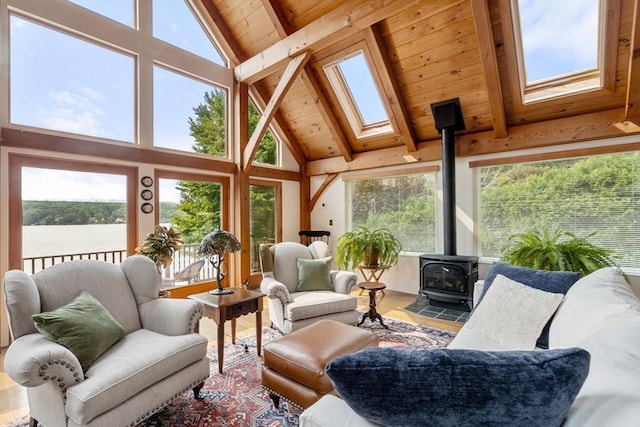 sunroom with a wood stove, a skylight, healthy amount of natural light, and a water view