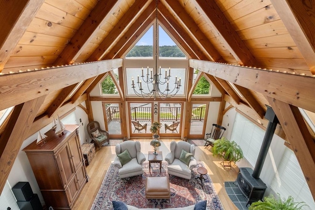 living area featuring light wood-type flooring, wooden ceiling, a wood stove, a chandelier, and french doors