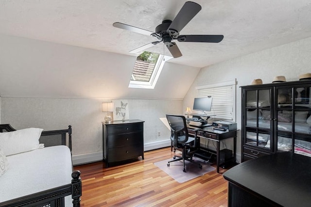 office space with a ceiling fan, wood finished floors, vaulted ceiling, a textured ceiling, and a skylight