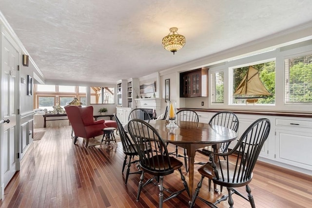 dining area with ornamental molding, plenty of natural light, and light wood-style floors