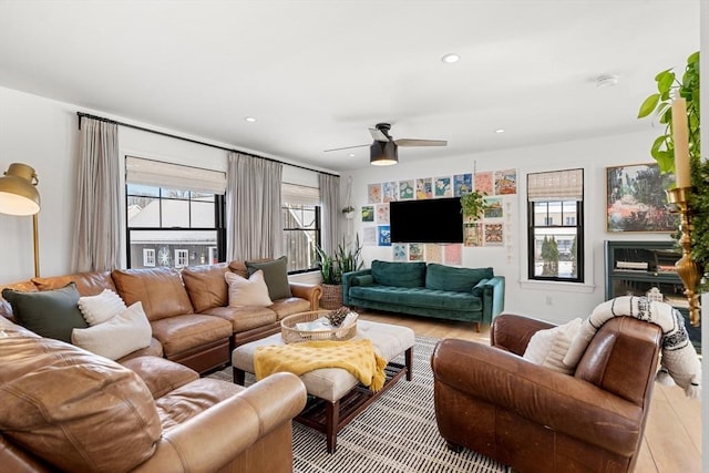 living room with ceiling fan and a fireplace