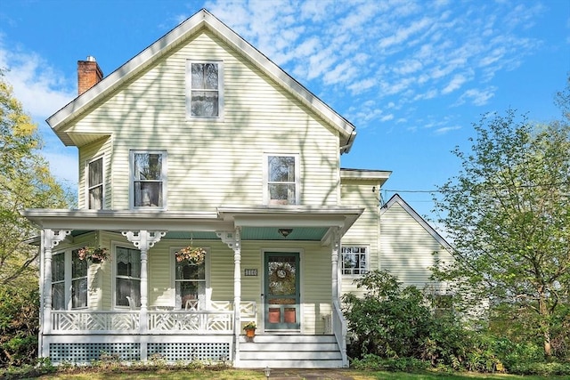 view of front of property with covered porch and a chimney
