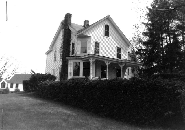 view of front of property featuring covered porch and a chimney
