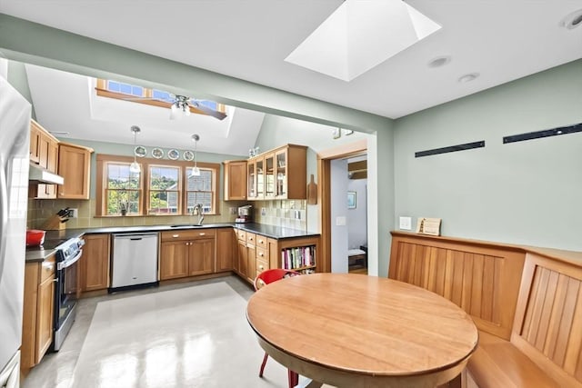 112 Hollett St, Scituate, MA 02066 - kitchen featuring a skylight, appliances with stainless steel finishes, tasteful backsplash, dark countertops, and a sink