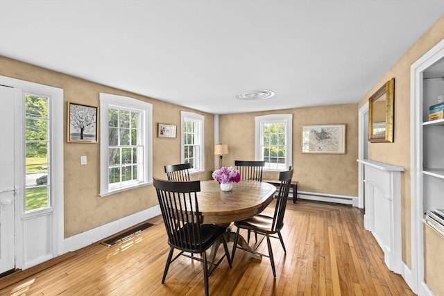 112 Hollett St, Scituate, MA 02066 - dining room with a baseboard radiator, light wood-type flooring, and baseboards