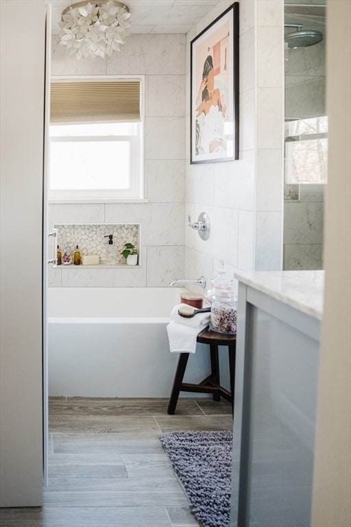 bathroom featuring tile walls, vanity, hardwood / wood-style flooring, and shower / bathtub combination