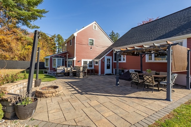 rear view of house featuring a fire pit and a patio