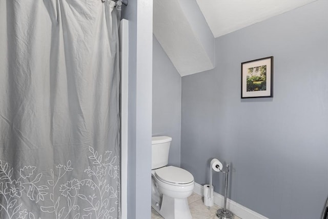 full bathroom with baseboards, toilet, a shower with shower curtain, lofted ceiling, and tile patterned floors