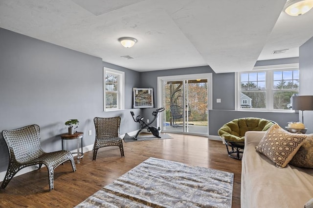 sitting room with visible vents, a healthy amount of sunlight, and wood finished floors