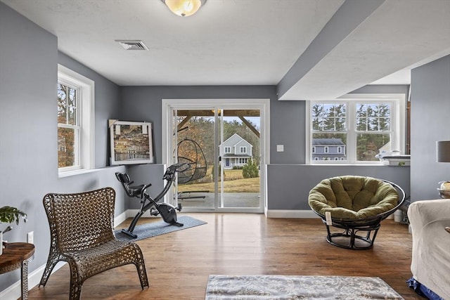 sitting room featuring wood finished floors, visible vents, and baseboards