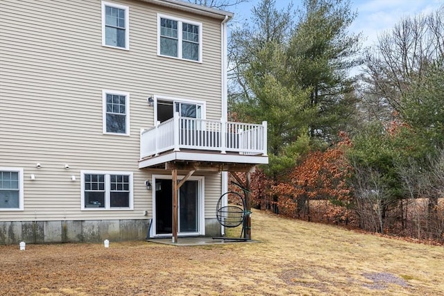 rear view of property featuring a deck and a yard