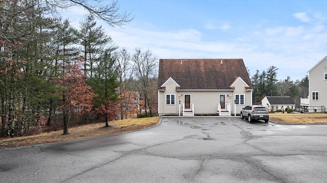 view of front of property with aphalt driveway, entry steps, and a shingled roof