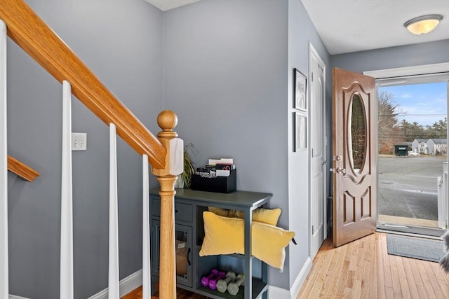 foyer with stairway, wood finished floors, and baseboards