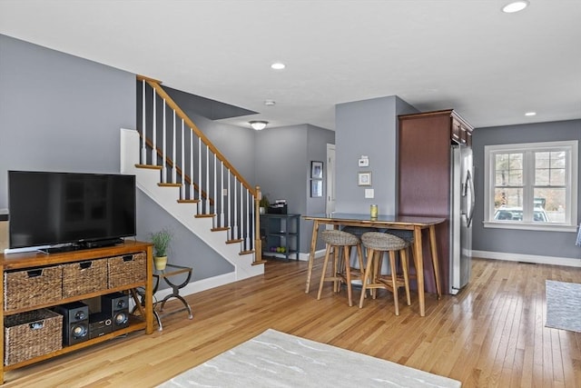 kitchen with recessed lighting, light wood-type flooring, freestanding refrigerator, and baseboards