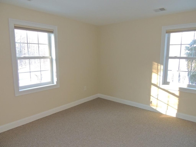 unfurnished room with a wealth of natural light and carpet