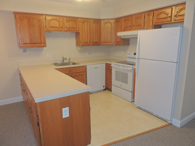 kitchen with white appliances, kitchen peninsula, and sink