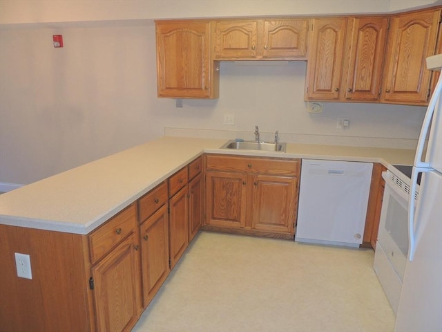 kitchen featuring sink, white appliances, and kitchen peninsula