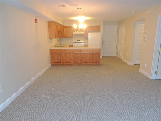 kitchen with range with electric stovetop, sink, white fridge, light colored carpet, and an inviting chandelier