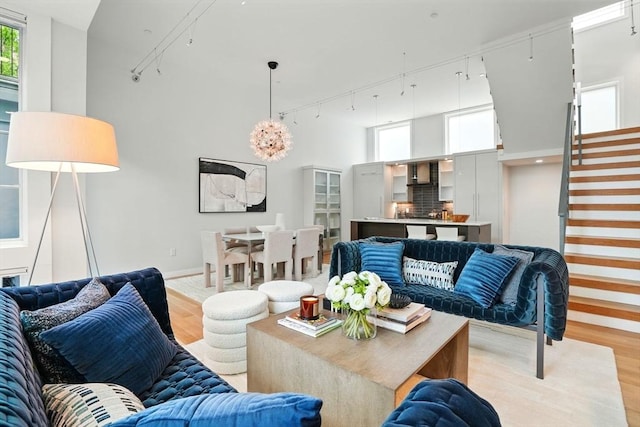 91 Kirkland St Unit 91, Cambridge, MA 02138 - living room with rail lighting, light wood-style flooring, stairs, and a high ceiling