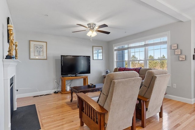 living room with ceiling fan and light hardwood / wood-style flooring