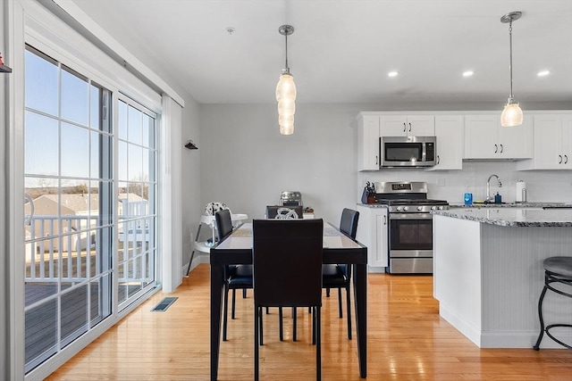 dining area with sink and light wood-type flooring