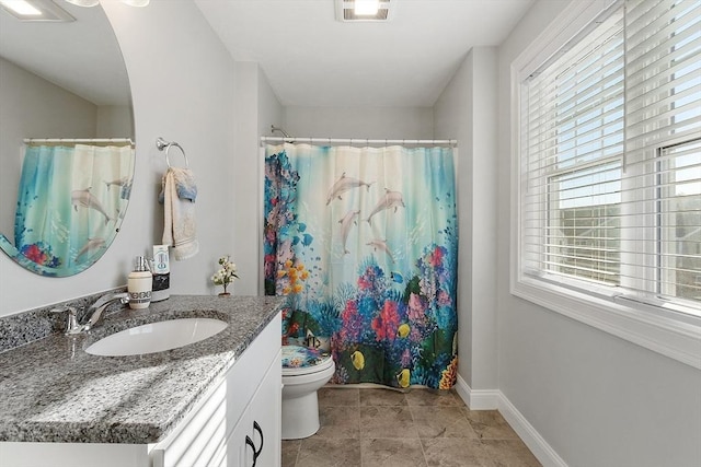 bathroom with walk in shower, plenty of natural light, vanity, and toilet