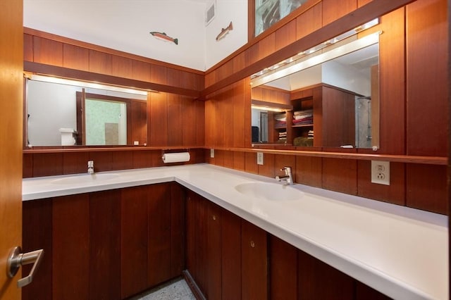 bathroom with vanity and wooden walls