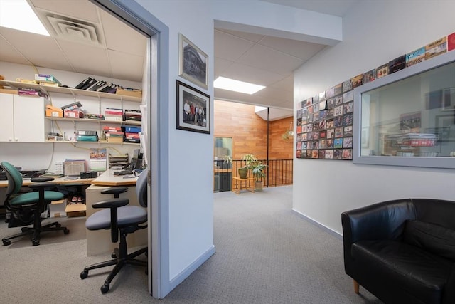 home office featuring wooden walls and light colored carpet