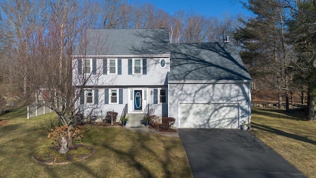 colonial inspired home with a front yard and a garage