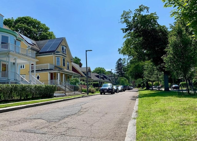 view of street featuring street lights, curbs, and sidewalks