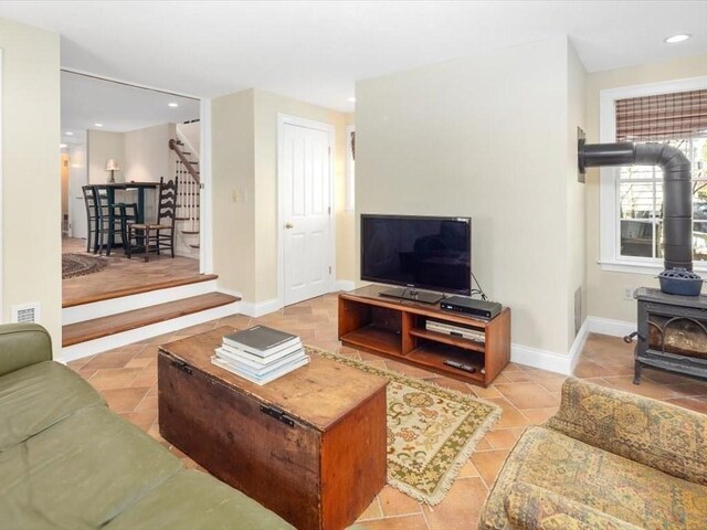 151 Pilgrim Rd, Weymouth, MA 02191 - tiled living room featuring stairs, a wood stove, recessed lighting, and baseboards