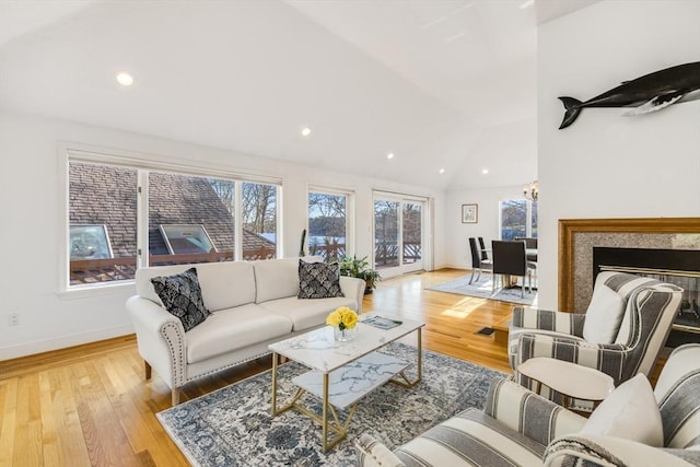 living room with recessed lighting, lofted ceiling, baseboards, and wood finished floors