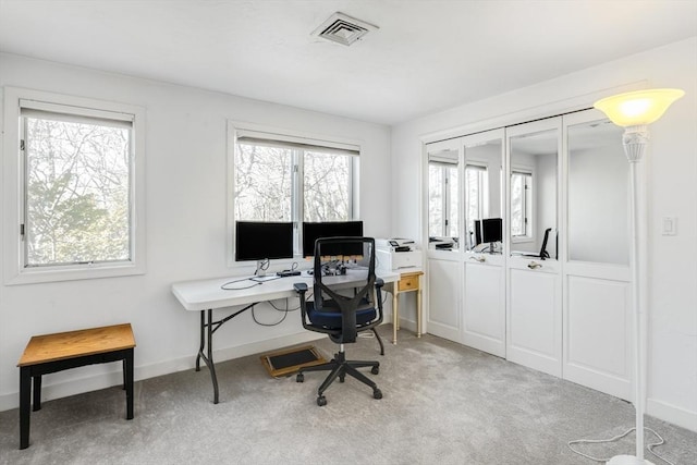 office area featuring visible vents, baseboards, and light carpet
