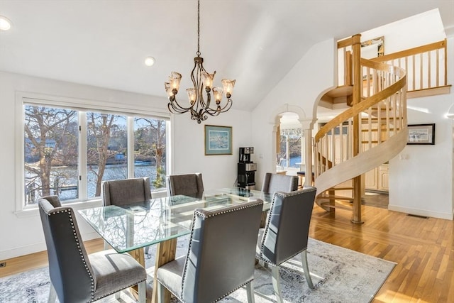 dining space featuring stairway, vaulted ceiling, a chandelier, baseboards, and ornate columns