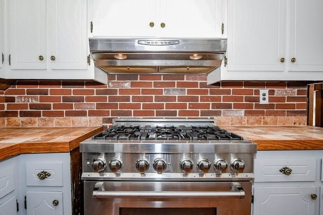 kitchen with range hood, high end stainless steel range oven, white cabinetry, butcher block countertops, and tasteful backsplash