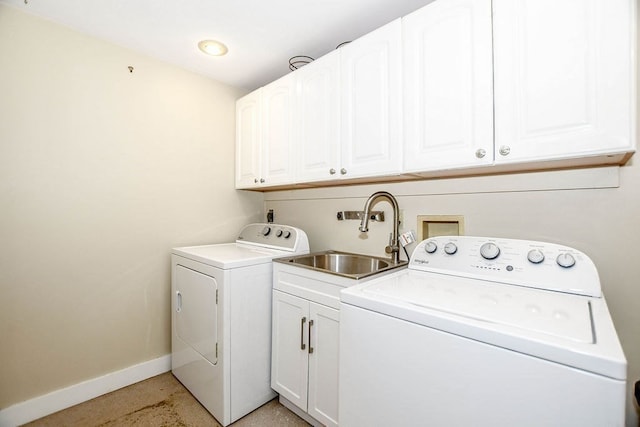 washroom with sink, washing machine and clothes dryer, and cabinets