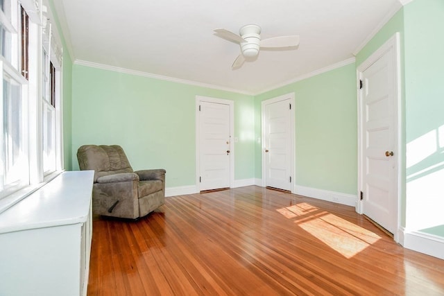 sitting room with ceiling fan, crown molding, and hardwood / wood-style floors