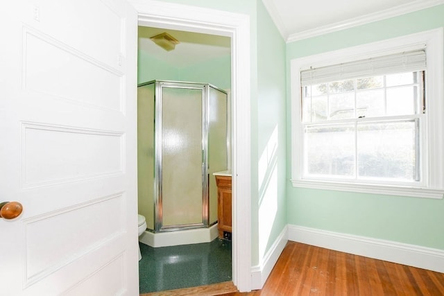 bathroom with a shower with door, a wealth of natural light, hardwood / wood-style floors, and toilet