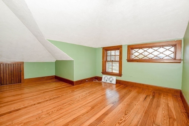 additional living space with lofted ceiling and light hardwood / wood-style flooring