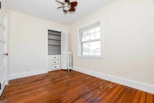 unfurnished bedroom featuring a closet, hardwood / wood-style flooring, radiator, and ceiling fan