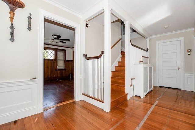 stairway with hardwood / wood-style floors, crown molding, and ceiling fan