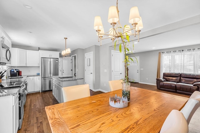 dining space featuring a notable chandelier, dark hardwood / wood-style floors, and sink