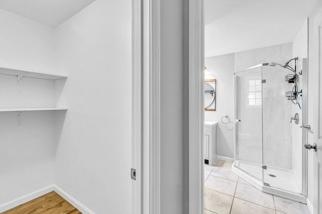 bathroom with a shower with shower door and tile patterned floors